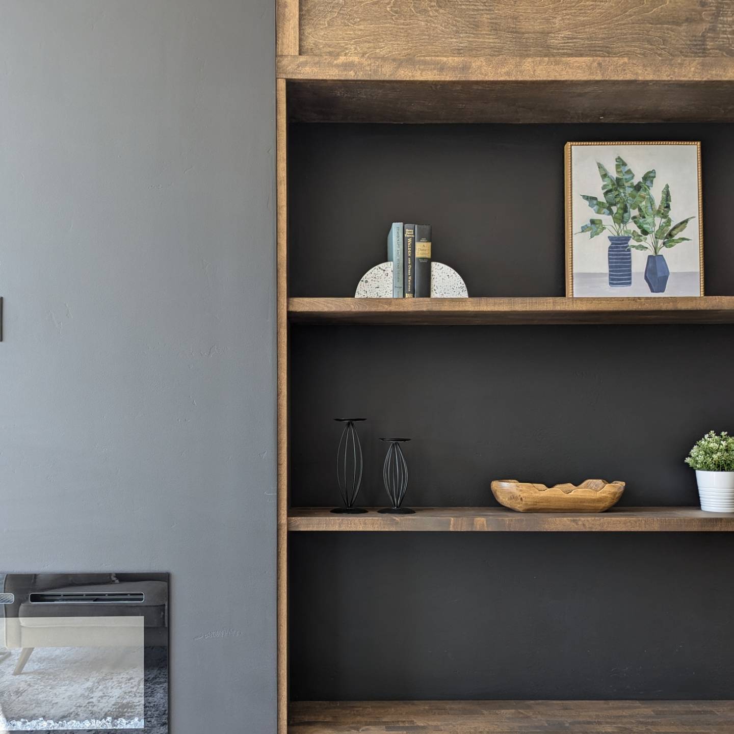Custom built-in bookcase with walnut shelves and fireplace surround