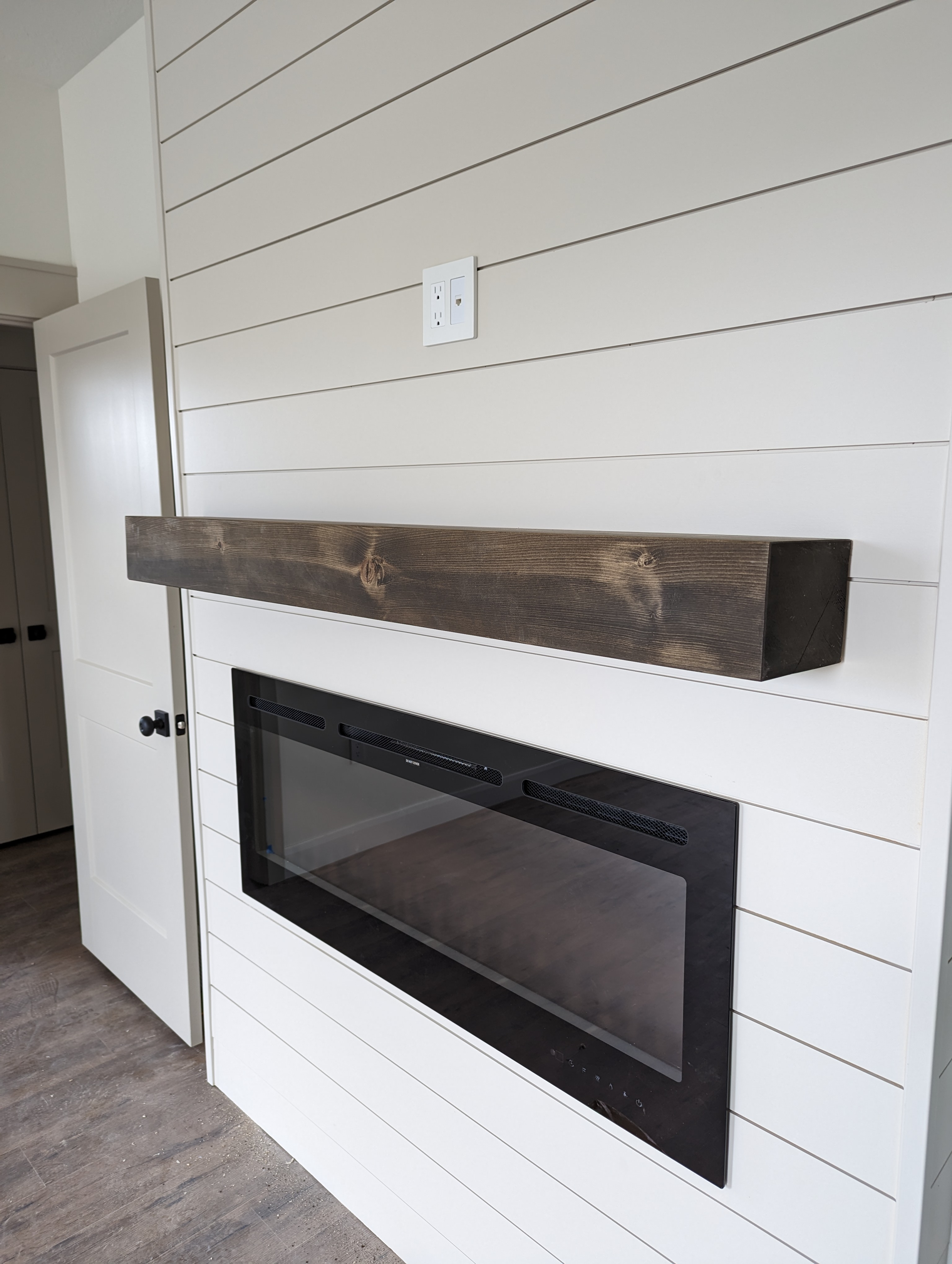 Shiplap fireplace wall with dark wood mantle